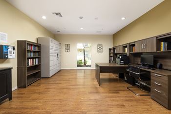 A room with a desk, chairs, and bookshelves.